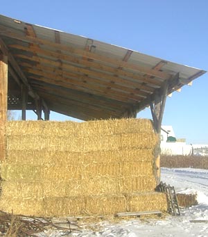 Straw stored on pallets under a roof