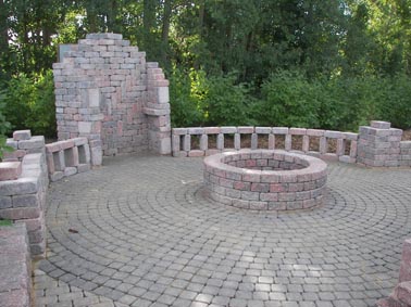 Roman Amphitheatre, Northern Quarystone used as a bench around the firepit, stacked and glued in a wall 6 feet high to provide firewood storage and a table.